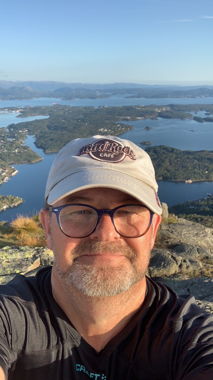 selfie på siggjo med hard rock caps man with caps with oceans and islands in background